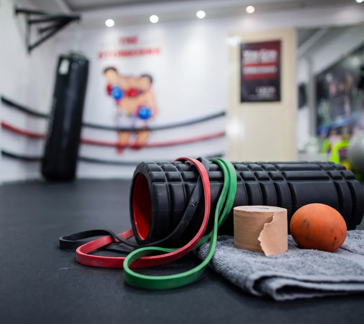 Foam roller, resistance bands, tape and a massage ball on the gym floor